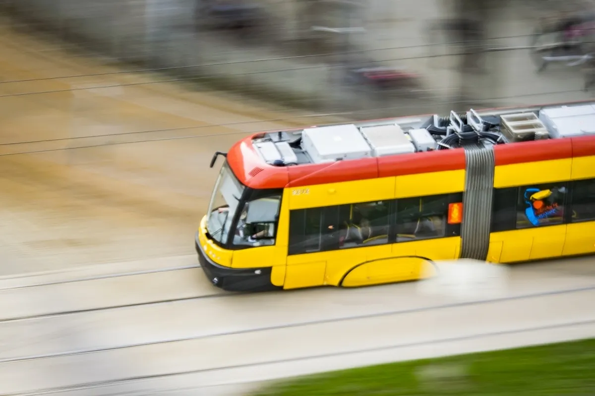 Yellow tram streaking across the frame in motion blur